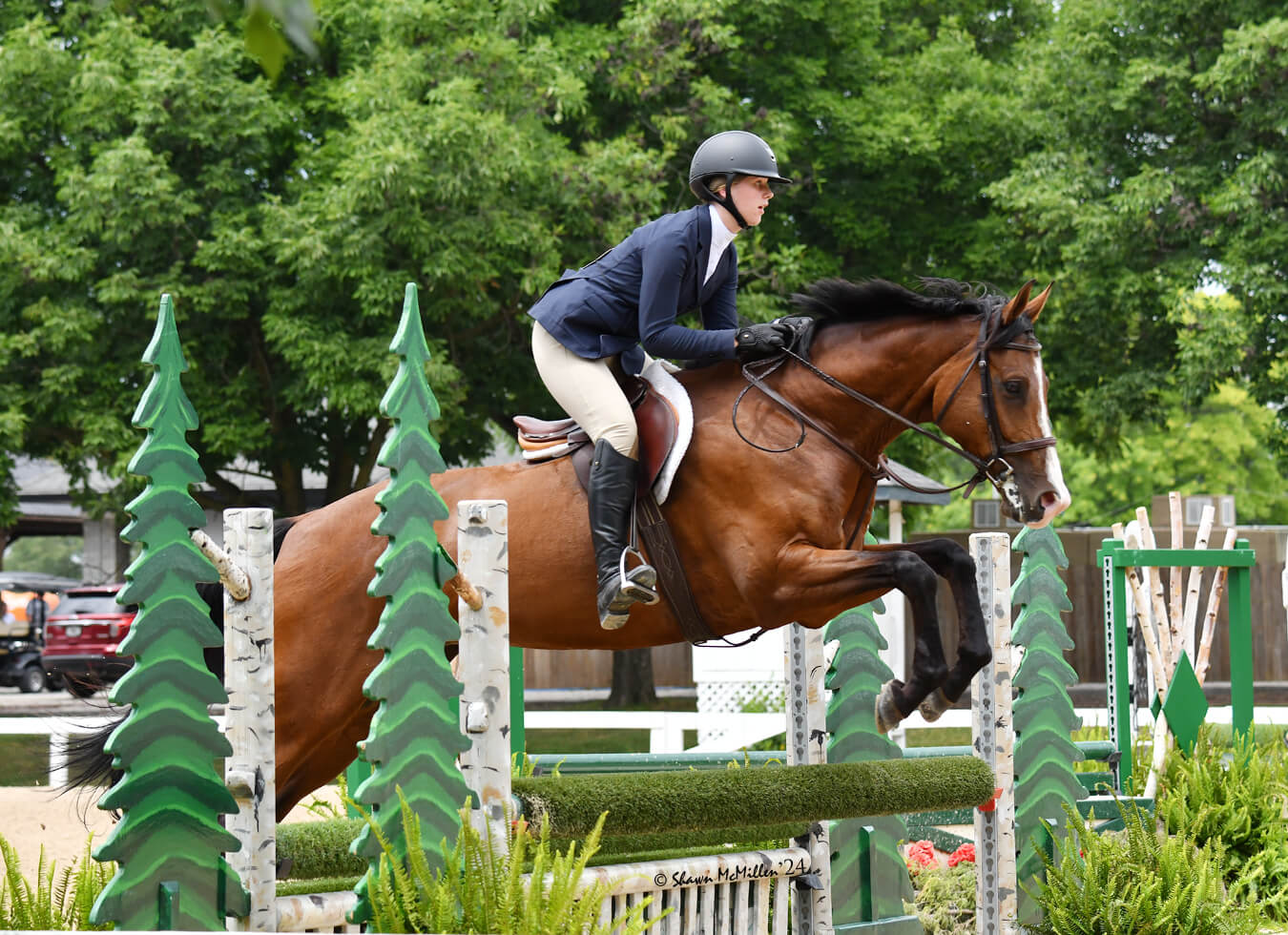 Seventh Farm: Isabella McCadden leaping over an ornate hurdle at a tournament